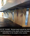 Stainless Steel Bradford Shelf Brackets 2 Pack Heavy Duty Quarter Inch Brackets For Countertops And Cabinets 24 Inches Wide By 7 Inches Deep By 7 Inches High Pre Drilled Mounting Holes Durable Home Improvement Support installed under a wooden shelf.