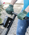 Person using Pro Push Broadcast Spreader 85 Lb Capacity with Durable Plastic Hopper in a garden setting