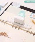 Go To 3 Hole Punch And 12 Piece Metal Ring Binder Set for A5 to A8 notebooks with white puncher and notebook on desk