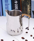 Stainless Steel 15 Ounce Espresso Steaming Pitcher For Milk Frothing And Latte Art With Dripless Spout Pro Grade Durable Anti Rust 304 Food Grade Milk Jug For Cappuccino on white table with coffee beans