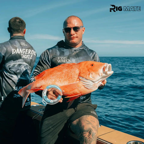 Fisherman holding a large snapper caught using 20 Lb Pre Tied Dropper Loop Rigs on a fishing line spool