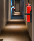 Heavy Duty Wall Mount Fire Extinguisher Bracket For 10lb Dry And 5lb CO2 Extinguishers installed in hallway, metal holder visible