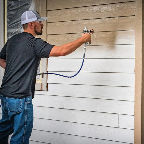 Person using Airless Spray Gun SG3 Pro Kit For Heavy Duty Coatings 3600 PSI Four Finger Trigger With Safety Lock on siding