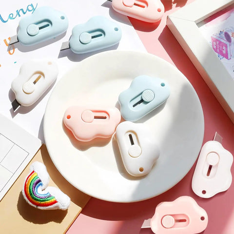 9 Pack Retractable Box Cutter Set With Mini Letter Opener And Cute Cloud Charm on white plate, pink and blue designs