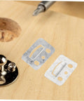 100 Piece Rugged Stainless Steel Gusset Plates Heavy Duty Wall Panel Clamps on wooden surface for DIY home builds.