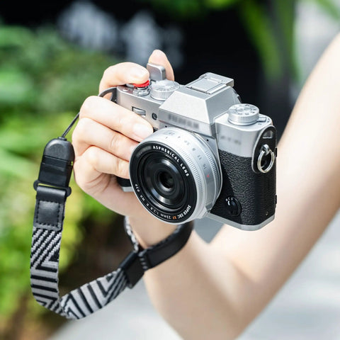 Person holding camera with XT30III Pro Thumb Grip With Shutter Button For XT30II XT20 XT10 Mirrorless Cameras Metal Thumb Rest, outdoors.