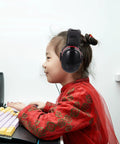 Kick Loud Noise To The Curb With Double Layer Over Ear Earmuffs designed for construction, worn by a child at a desk.