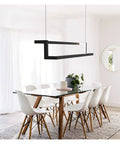Modern LED Pendant Light Rock Solid Aluminum Body With Effortless Remote Dimming And Soft Warm White Glow in dining room over table.