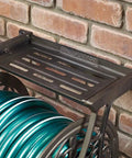 NeverLeak Decorative Wall Mount Hose Reel In Brown For Outdoor Yards Holds 125 Ft Of Five Eighths Inch Hose mounted on brick wall