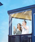 Two people enjoying drinks behind a Built Tough 3 By 6 Foot Heavy Duty Clear Vinyl Tarp With Reinforced Grommets 14 Mil Waterproof Pvc Shield.