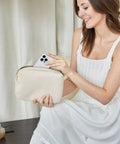 Woman holding Beige Travel Electronics Organizer Case For Women, Slim Cord Keeper and Cable Pouch with phone inserted