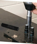 Close-up of Hydraulic Punch Driver Kit Pro Grade Knockout Tool Set for metal conduit and sheet punching in use on a workbench.
