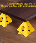 Premium Solid Gold 36 Piece Painters Pyramid Stands For Cabinet Doors And Furniture Risers lifting a wooden board off the surface.
