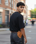 Man walking with Leather Multitool Sheath EDC Belt Organizer For Flashlight And Tools on his belt, urban background