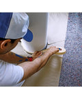 Painter applying Masking Tape For Curves Ultra Flexible 19mm By 25m Pro Grade Tape on smooth surface around a curved edge