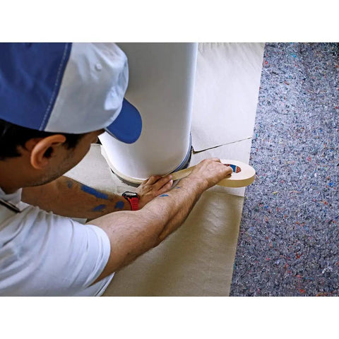 Painter applying Masking Tape For Curves Ultra Flexible 19mm By 25m Pro Grade Tape on smooth surface around a curved edge