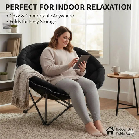 Woman relaxing on XXL Folding Round Camping Chair With Super Cushioned Padded Seat For All Day Comfort Heavy Duty Frame.