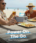 Compact 5000mAh MagSafe Portable Charger With Rock Solid Magnetic Grip And Slick Wireless Power Bank charging iPhone at beach.
