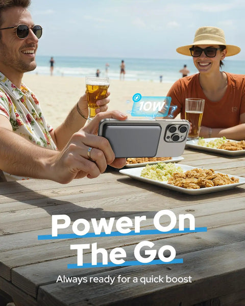 Compact 5000mAh MagSafe Portable Charger With Rock Solid Magnetic Grip And Slick Wireless Power Bank charging iPhone at beach.