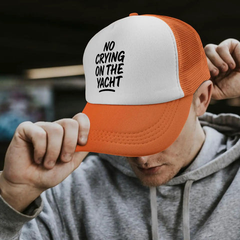 Man adjusting orange and white cap with 'No Crying on the Yacht' text, showcasing Lightweight Dope Baseball Caps For Men And Women.