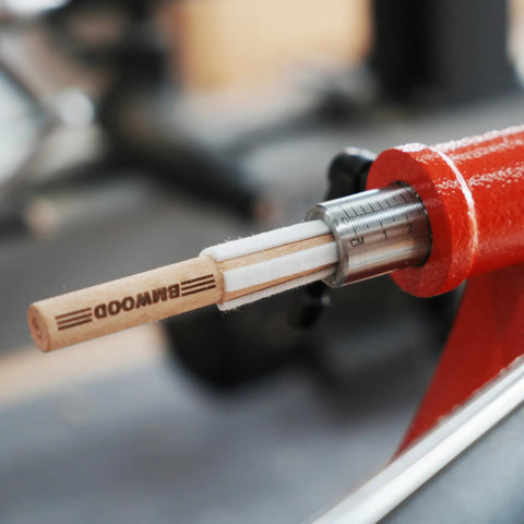 MT2 Cleaner For Wood Lathe Spindles inserted in a red lathe, showing wooden handle and measurement markings