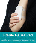 Sterile gauze pad taped to forearm with white adhesive strips