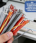 Hand holding colored jumper wires with tips, note about flexibility, next to breadboard; 840 Piece Jumper Wire Kit for Solderless Breadboard with 14 Lengths U Shape Wires Magnetic Jumpers Alligator Clip Test Leads Box and Tweezers Great for Prototyping DIY Electronics