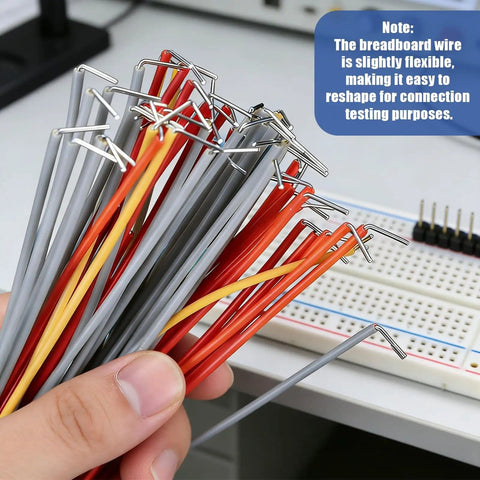 Hand holding colored jumper wires with tips, note about flexibility, next to breadboard; 840 Piece Jumper Wire Kit for Solderless Breadboard with 14 Lengths U Shape Wires Magnetic Jumpers Alligator Clip Test Leads Box and Tweezers Great for Prototyping DIY Electronics