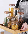 Straight Up Solid Airtight Coffee And Tea Storage Canister With Smooth Wood Lid, various canisters on a tray, showcasing storage options.