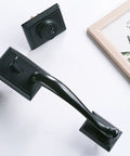 Oil Rubbed Bronze door handle set with keyed and dummy grip on white surface with decorative frame