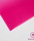 Close-up of waterproof Pink Bubble Mailers 8.5x11 Inch 30 Pack with self seal and cushioned protection for shipping, shown against water droplets.