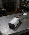 Heavy Duty DC Voltage Step Down Converter Swaps 36V Or 72V Straight To 12V Pulling 120 Watts And Ten Amps For Trucks Boats And Trailers on metal table.