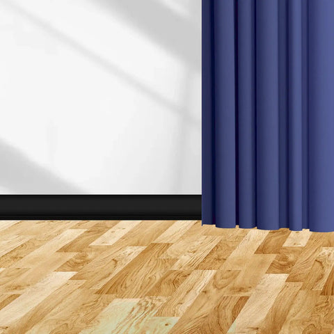 Flexible Black Vinyl Wall Base 5 Inch By 20 Foot Molding Trim With 1 Inch Crease next to blue curtain on wooden floor.