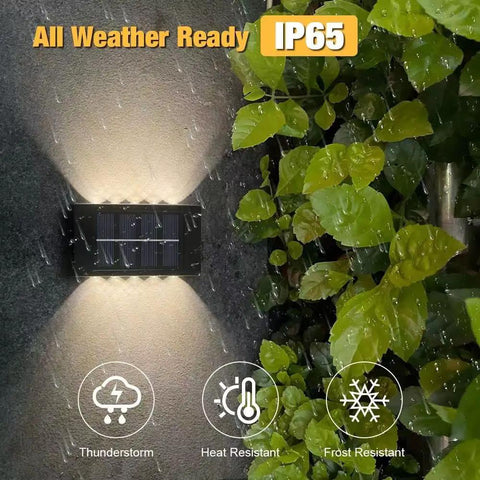 Six Pack Solar Outdoor Lights With 10 LED Waterproof Dusk To Dawn Fence Wall Deck Step Lighting Garden Pathway Yard Patio Warm White Glow For Outdoor Spaces in rain showcasing IP65 weather resistance.