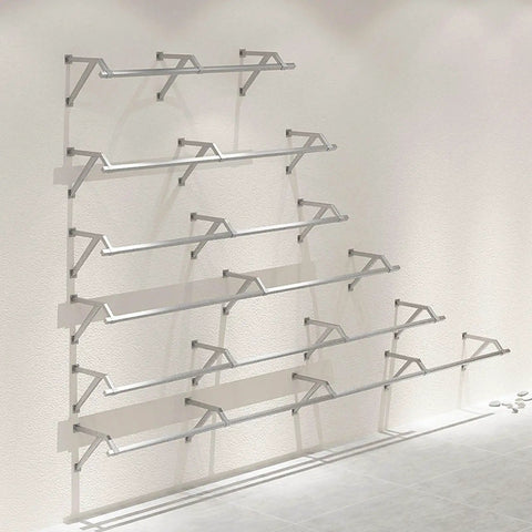 Industrial Pipe Wall Shelf Rustic Metal Display Rack for Clothing and Laundry Garment Bar on a white wall