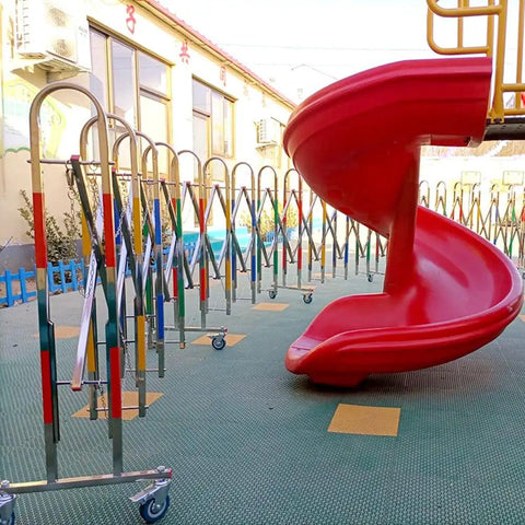 Rock Solid Stainless Steel Retractable Crowd Control Barrier Gate With Smooth Rolling Wheels in front of a playground slide.