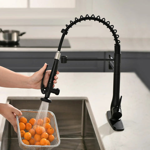 GIMILI Matte Black Commercial Kitchen Faucet with Pull Down Sprayer in use, rinsing oranges in a modern sink.