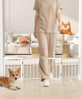 Short Dog Gate For Tiny Paws Under Fifteen Pounds With Foldable Four Panel Barrier Expands To Forty Eight Inches Wide, featuring corgi with owner walking by.