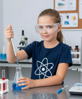 Child wearing 10 Pack Kid Safe Lab Goggles Set With Lightweight Clear Lenses Protective Eye Glasses For Small Faces Kid Friendly Science Glasses With Snug Fit For School Experiments And Home Science Fun, conducting a science experiment with beaker and pipette.