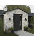 Lit Wish LED Outdoor 1 Light Wall Lantern in textured black with etched white linen glass on stone entryway of a house.