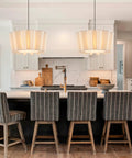 Modern kitchen island with two large pendant lights, striped bar stools, marble backsplash, wooden accents