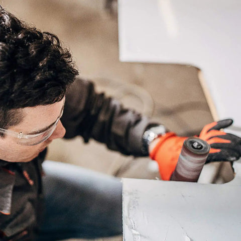 Man using Garage Grade Drill Press Sanding Drum Kit with sanding sleeve on wood, working on a project in workshop.