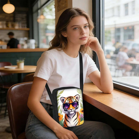 Woman wearing Hands Free Crossbody Sling Bag For Women And Men Ultra Lightweight Everyday Chest Pack With Adjustable Strap And Zipper Small Messenger Style Bag For Travel Work And Daily Use Tiger Print With Sunglasses in a cafe