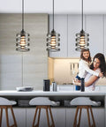 Two Pack Black Spiral Cage Pendant Lights With Clear Glass Shade And Frosted Inner Glass over kitchen island