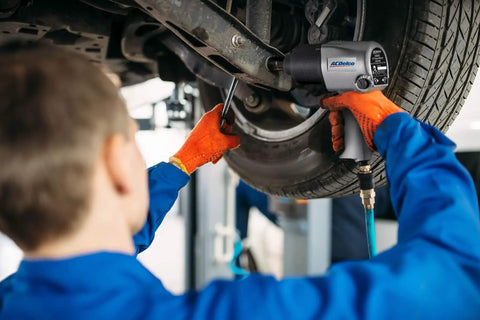 Mechanic using Hella Tough Pneumatic Shop Beast Featuring One Half Inch Five Speed Impact Wrench and Three Eighth Inch Ratchet for tire work.