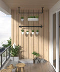 Built Like A Tank Wall Mounted Clothes Rack 3 Pack Black Industrial Pipe with potted plants on a balcony wall.