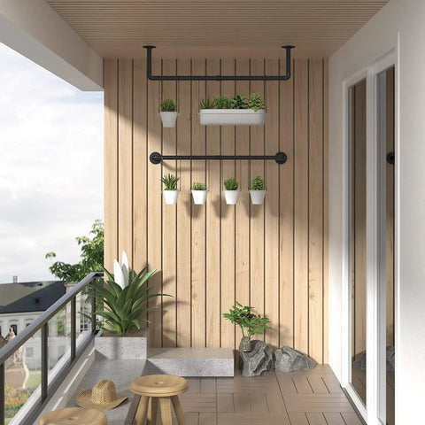 Built Like A Tank Wall Mounted Clothes Rack 3 Pack Black Industrial Pipe with potted plants on a balcony wall.