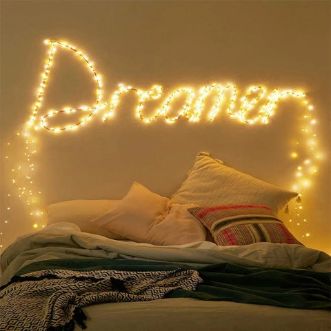 Battery Operated Fairy String Lights 10 Feet With 30 Warm White LEDs arranged to spell 'Dreamer' above a cozy bed setup