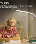 LED Desk Lamp With Clamp For Home Office White USB Port Desk Light Eye Caring Dimmable Task Lamp illuminating a desk for studying.