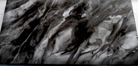 Epoxy resin countertop surface with marbled black and white finish, enhanced with Sanding Disc Variety Pack For Stone, Tile, And Countertops, 9 Round Abralon And Abranet Polishing Discs With Grits 220 To 4000, Perfect For Epoxy Resin Finishing And A Smooth DIY Surface Makeover.